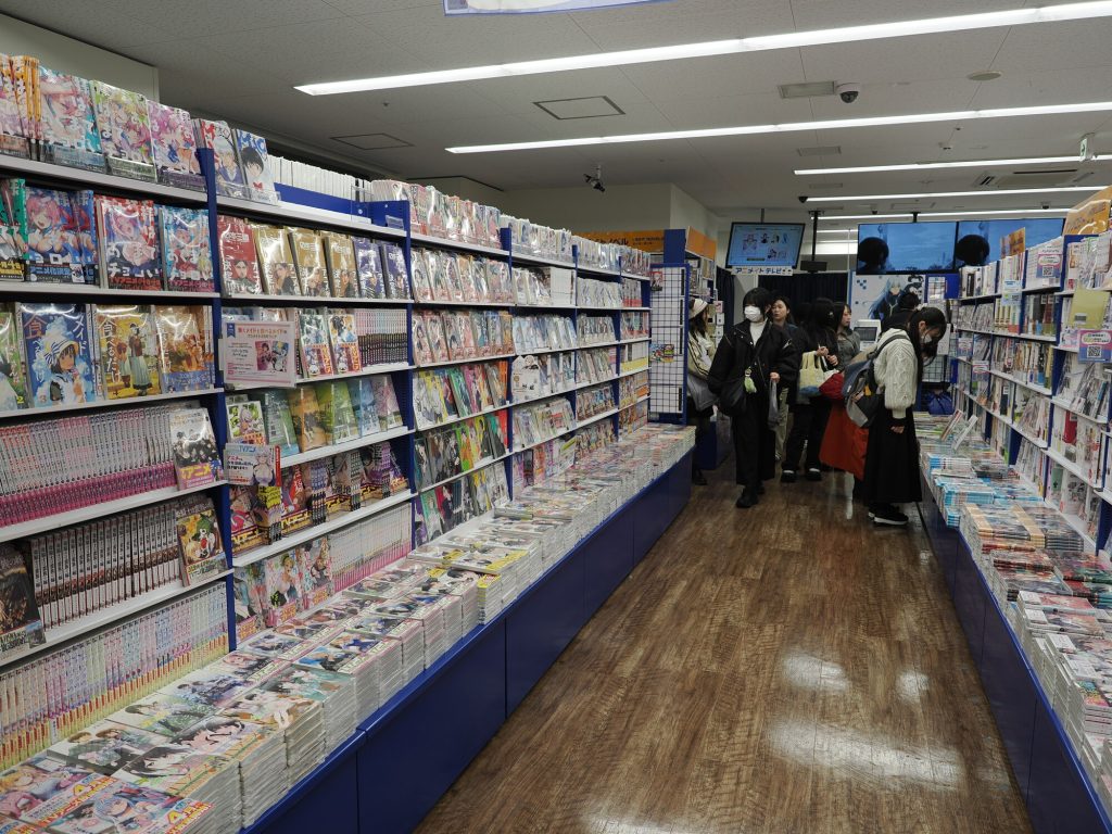 Korytarz działu manga w Animate Ikebukuro - regały po obu stronach pełne tomów, klienci przeglądający