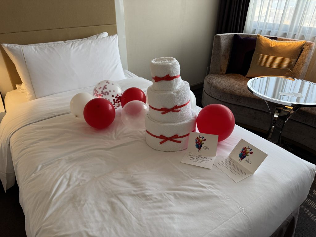 Urodzinowe dekoracje w pokoju hotelowym - tort z ręczników i balony