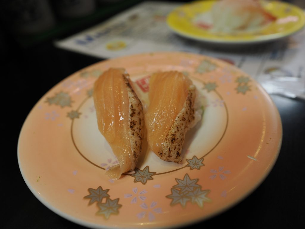 Dwa nigiri z pieczonym łososiem yaki-salmon na różowym talerzyku Ganso Zushi