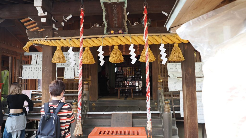 Wejście do haiden świątyni Hanazono Inari Jinja - shimenawa i zuzia z plecakiem