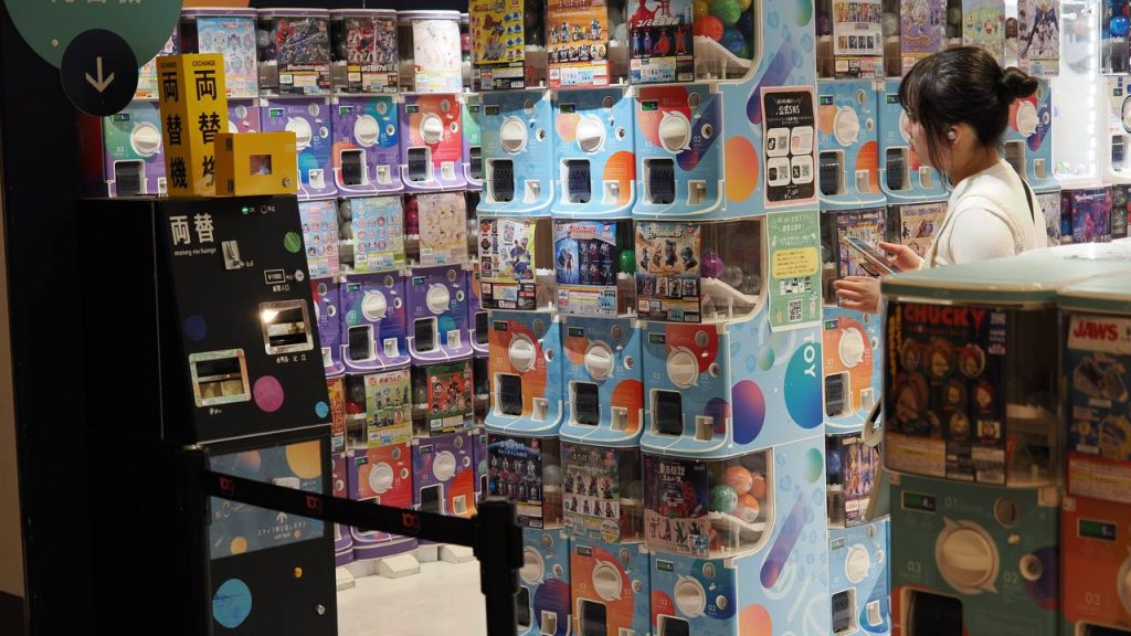 Kobieta przy automatach gacha w C-pla, sciany automatow, maszyny wymiany monet 両替