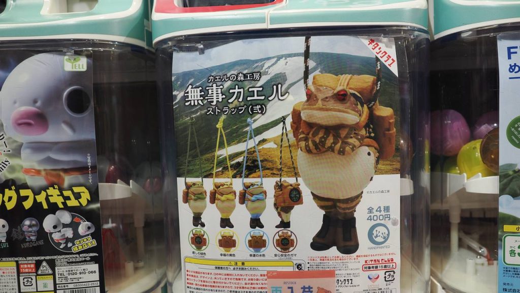 Automat gacha Muji Kaeru - żaby turystki z plecakami i kompasem, breloki na sznurku, 400 JPY