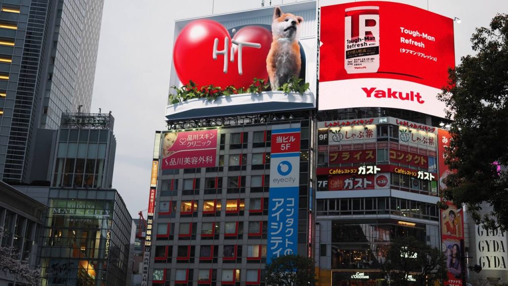 Wielki billboard 3D z psem Shiba Inu nad Shibuya Crossing - reklama HiT, obok Yakult Tough-Man Refresh