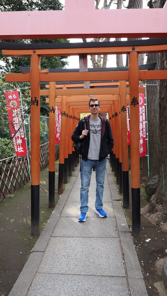 Kamil stojący w tunelu pomarańczowych torii w świątyni Hanazono Inari Jinja w Parku Ueno