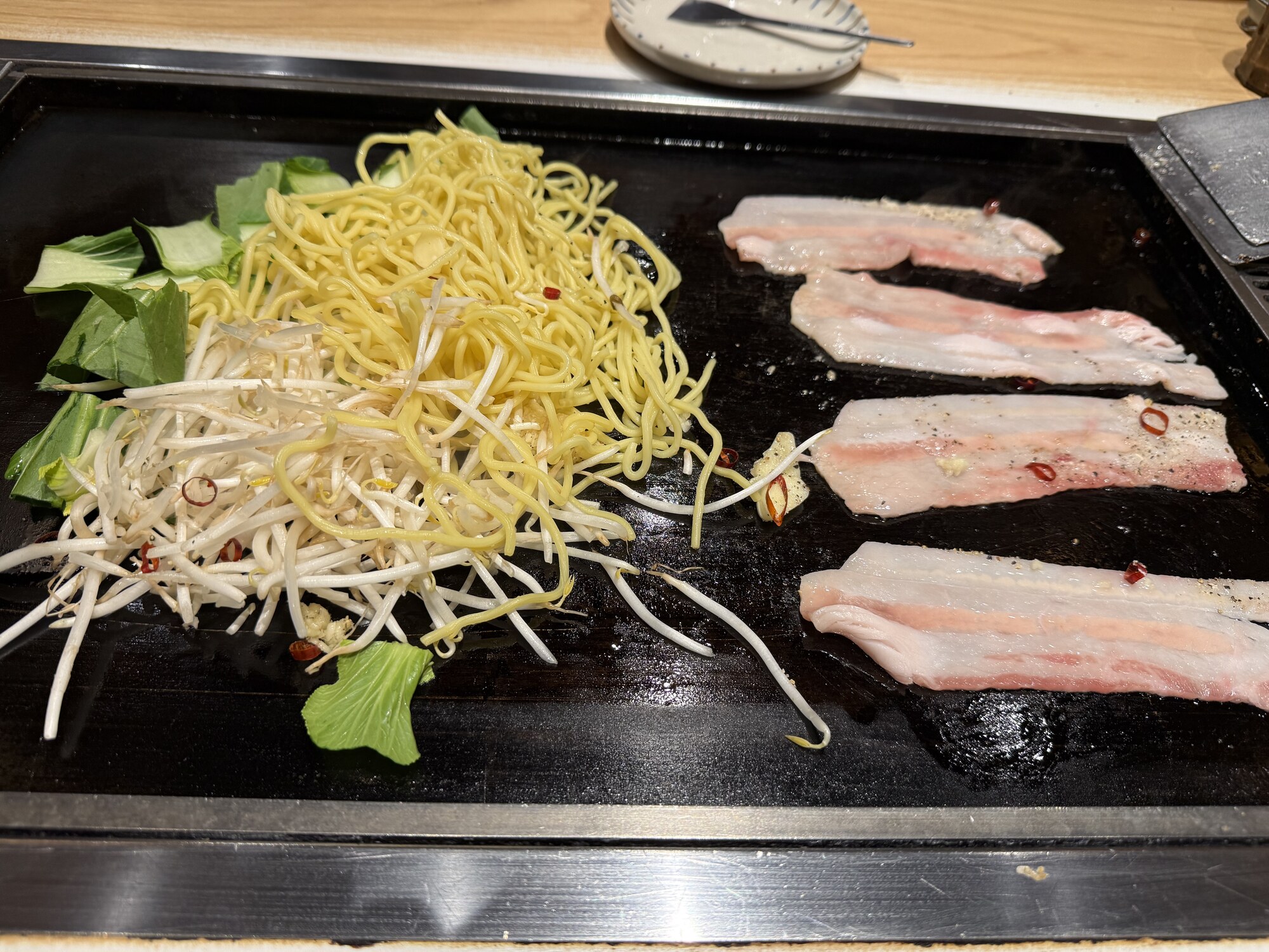 Grill teppan z boczkiem wieprzowym, makaronem yakisoba, kiełkami i kapustą