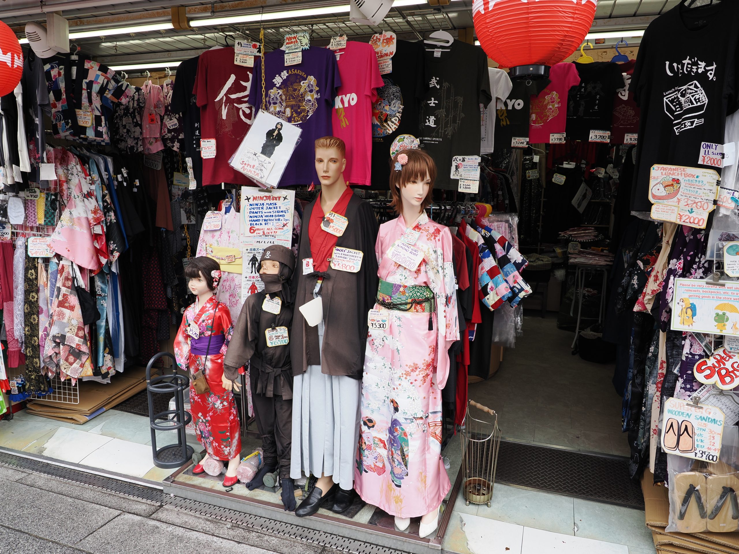 Sklep z pamiątkami: manekiny ubrane jako ninja, samuraj i dama w kimono; koszulki z napisami po japońsku; szyld NINJAIT