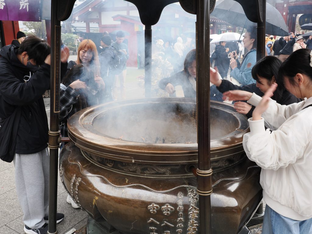 Kocioł kadzidlany przy Senso-ji — turyści wdychają oczyszczający dym kadzidła