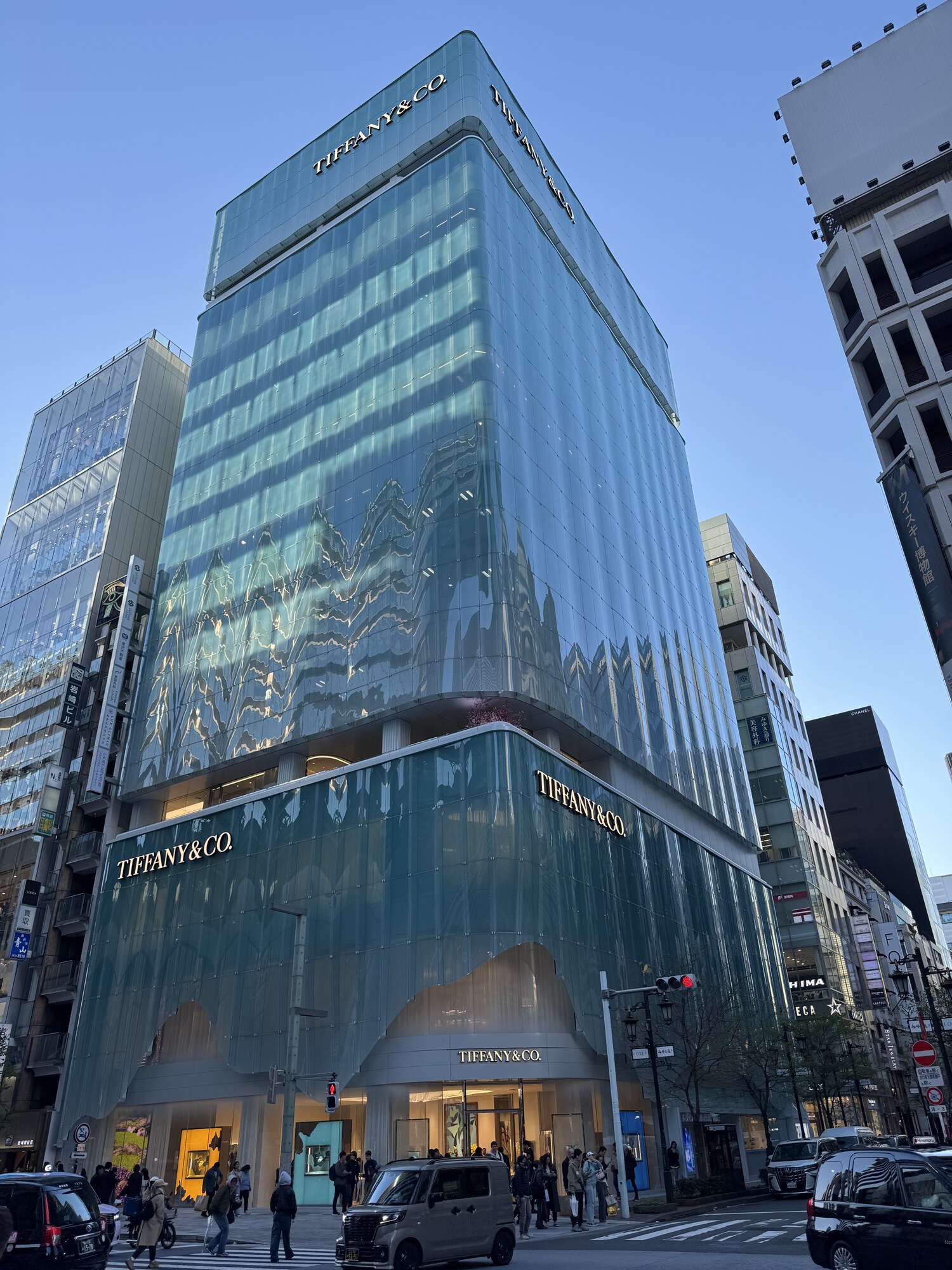 Budynek Tiffany and Co w Ginzie ze szklaną turkusową fasadą, obok szyld Muzeum Whisky