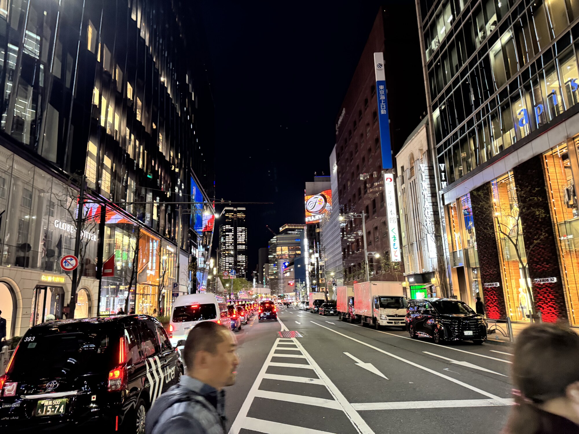 Nocna ulica Ginzy z taksówkami Limo Taxi i szyldami korporacji Tokio Marine