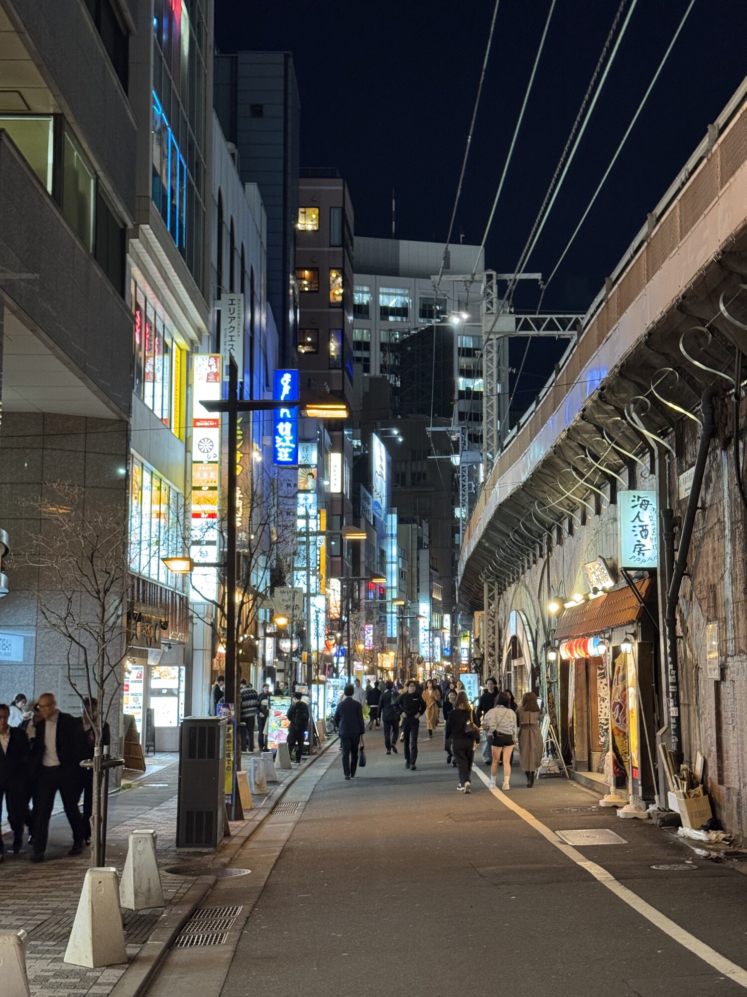 Wąska nocna uliczka przy izakayach pod łukami wiaduktu kolejowego, okolice Yurakucho