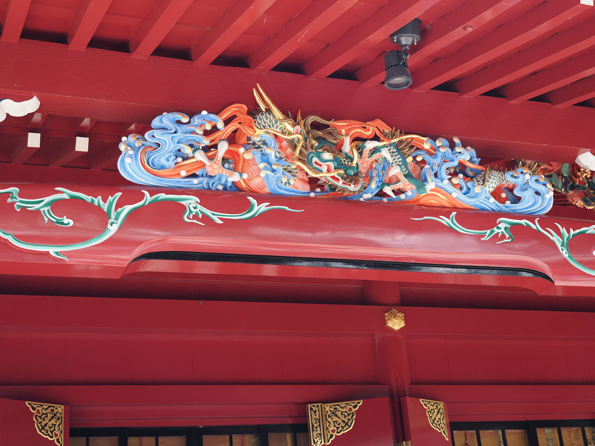 Kolorowa rzeźba smoka Kuzuryu na belce hali Hakone Jinja — złoto, niebieski i pomarańcz