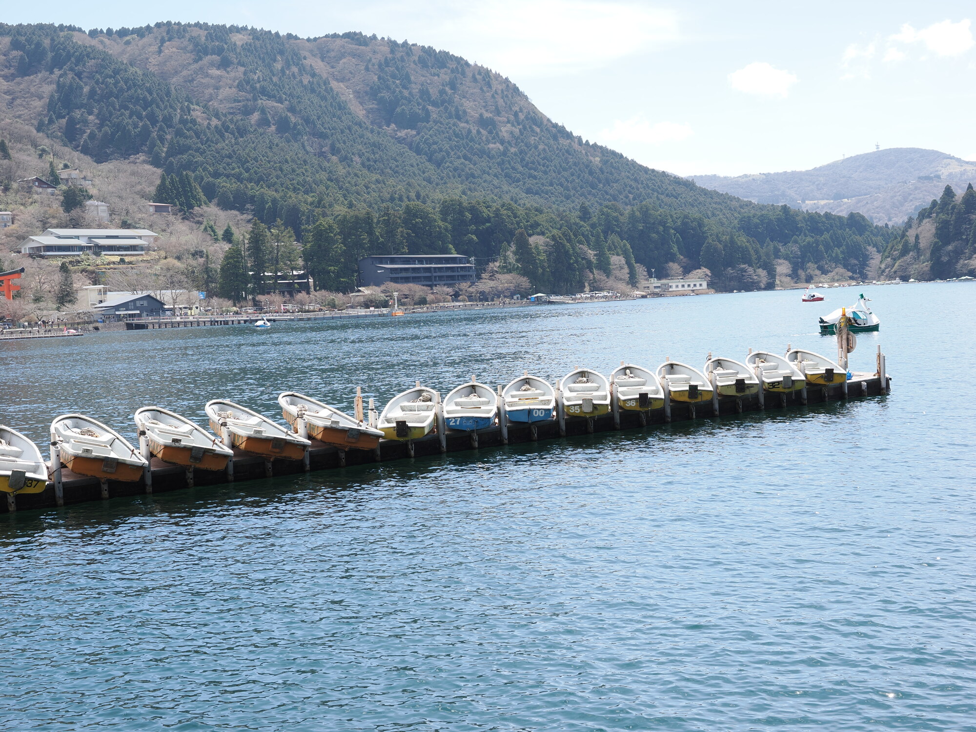 Łodzie wiosłowe cumujące przy pomoście na jeziorze Ashinoko w Hakone