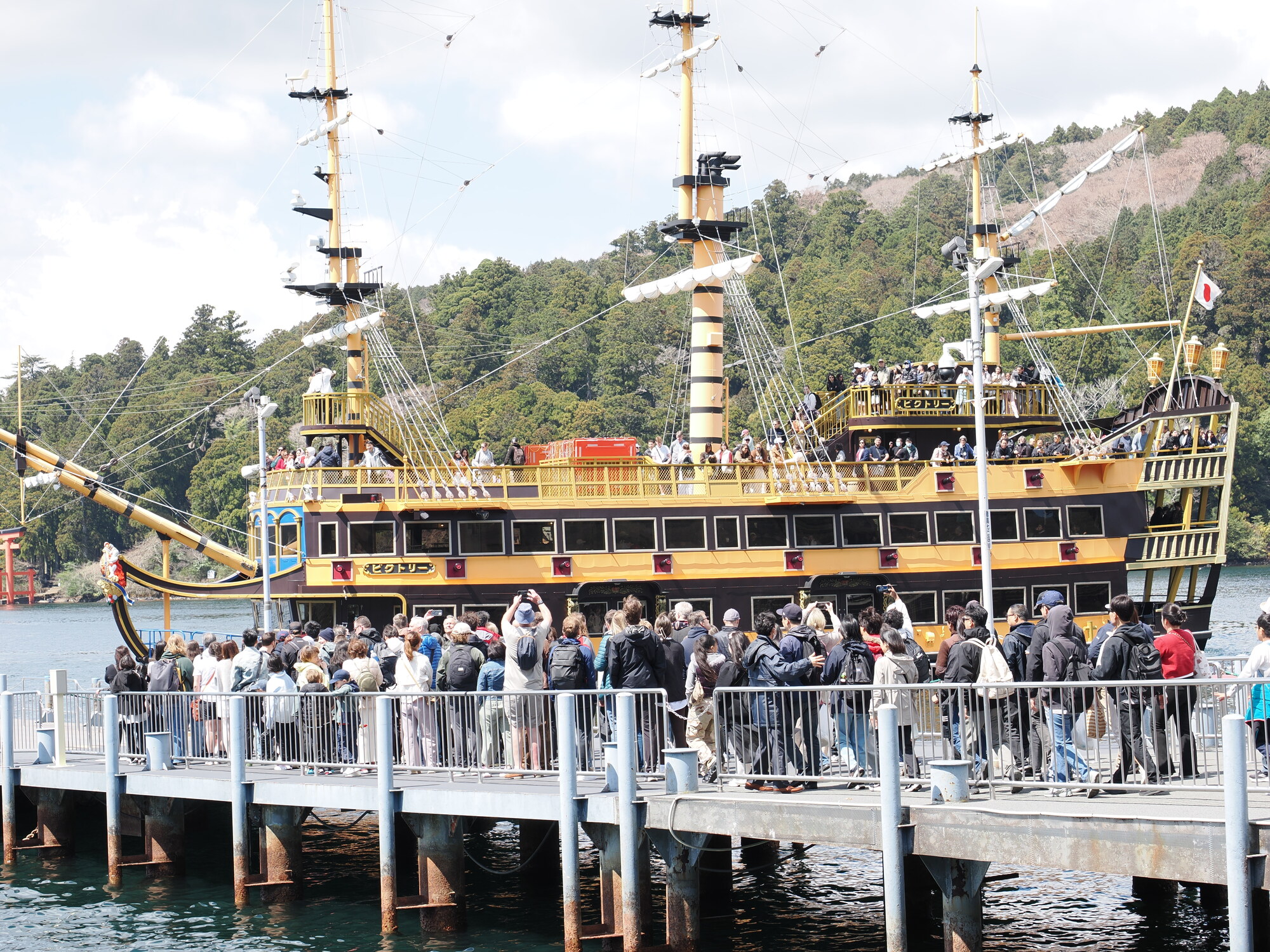 Piracki statek wycieczkowy Victory cumujący przy przystani na jeziorze Ashinoko, tłum turystów na pokładzie