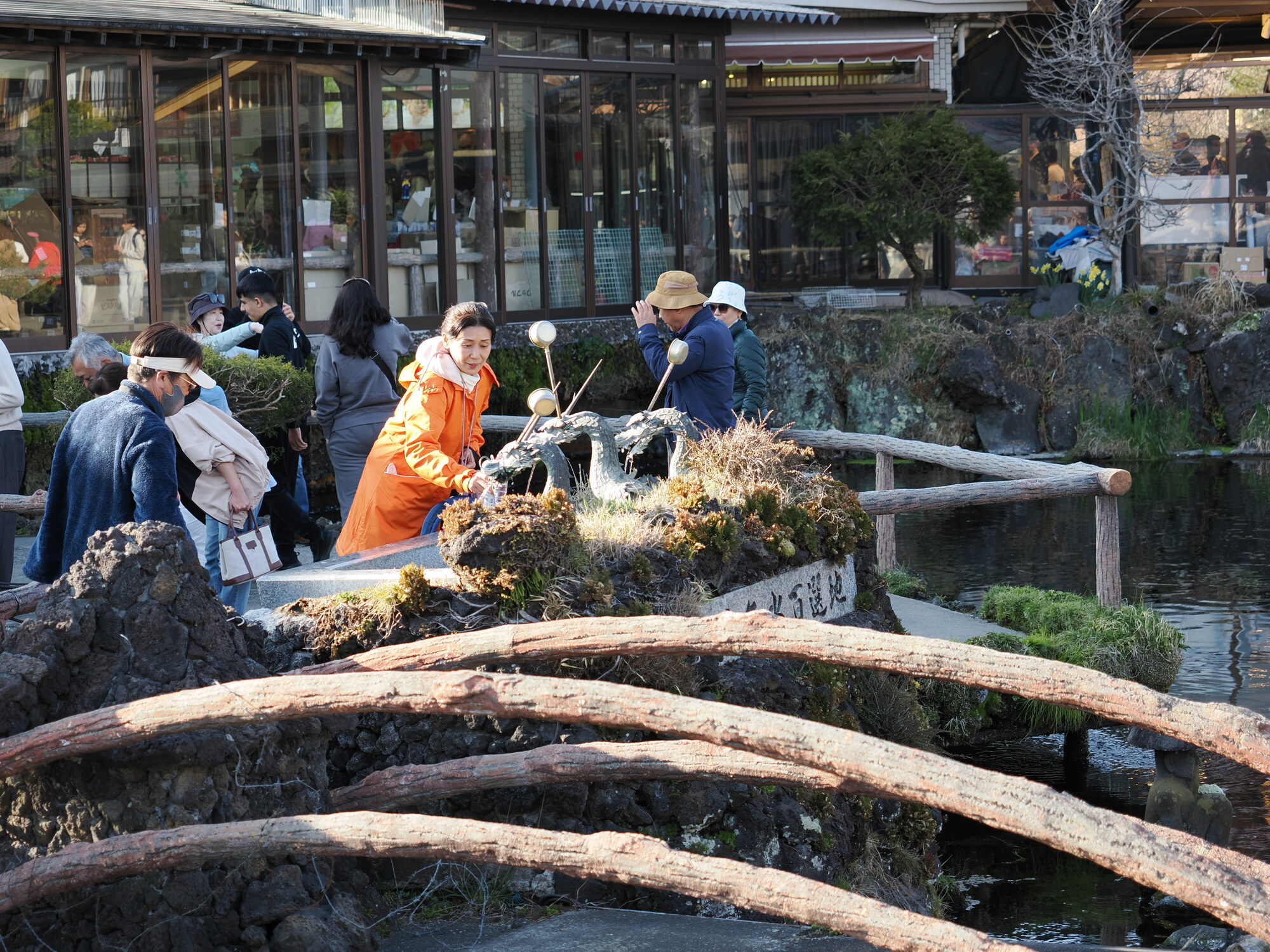 Kobieta przy fontannie smoka i rzeźbach na mostku w Oshino Hakkai