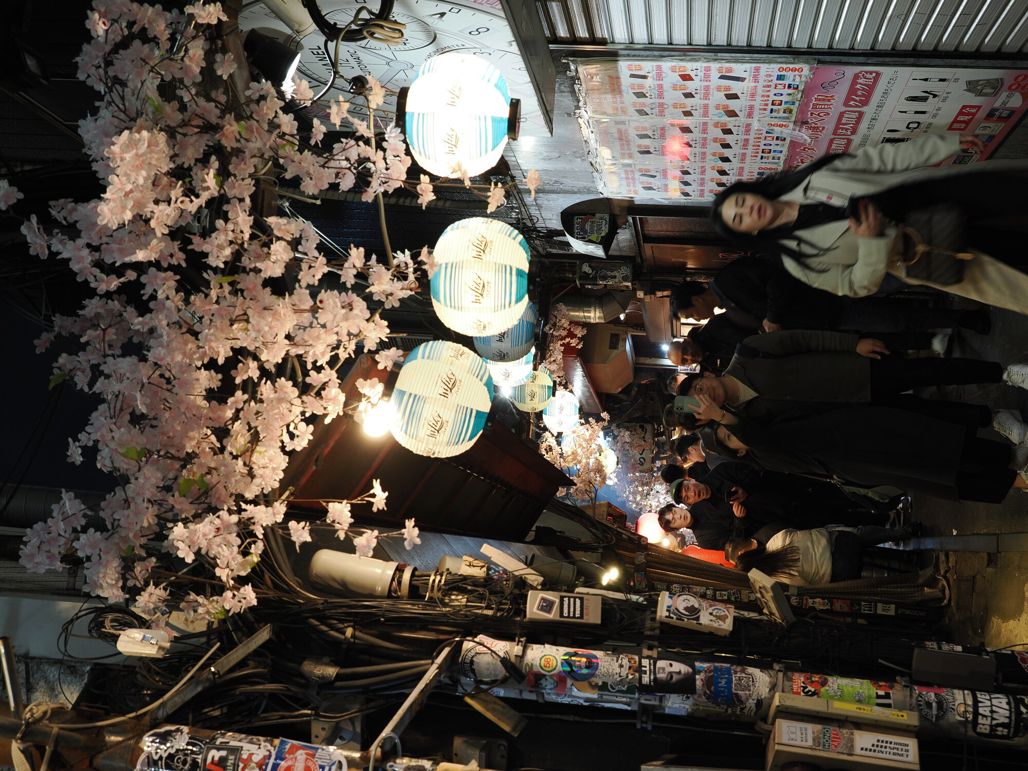 Omoide Yokocho Memory Lane w Shinjuku nocą — lampiony sakury, wąska uliczka pełna ludzi