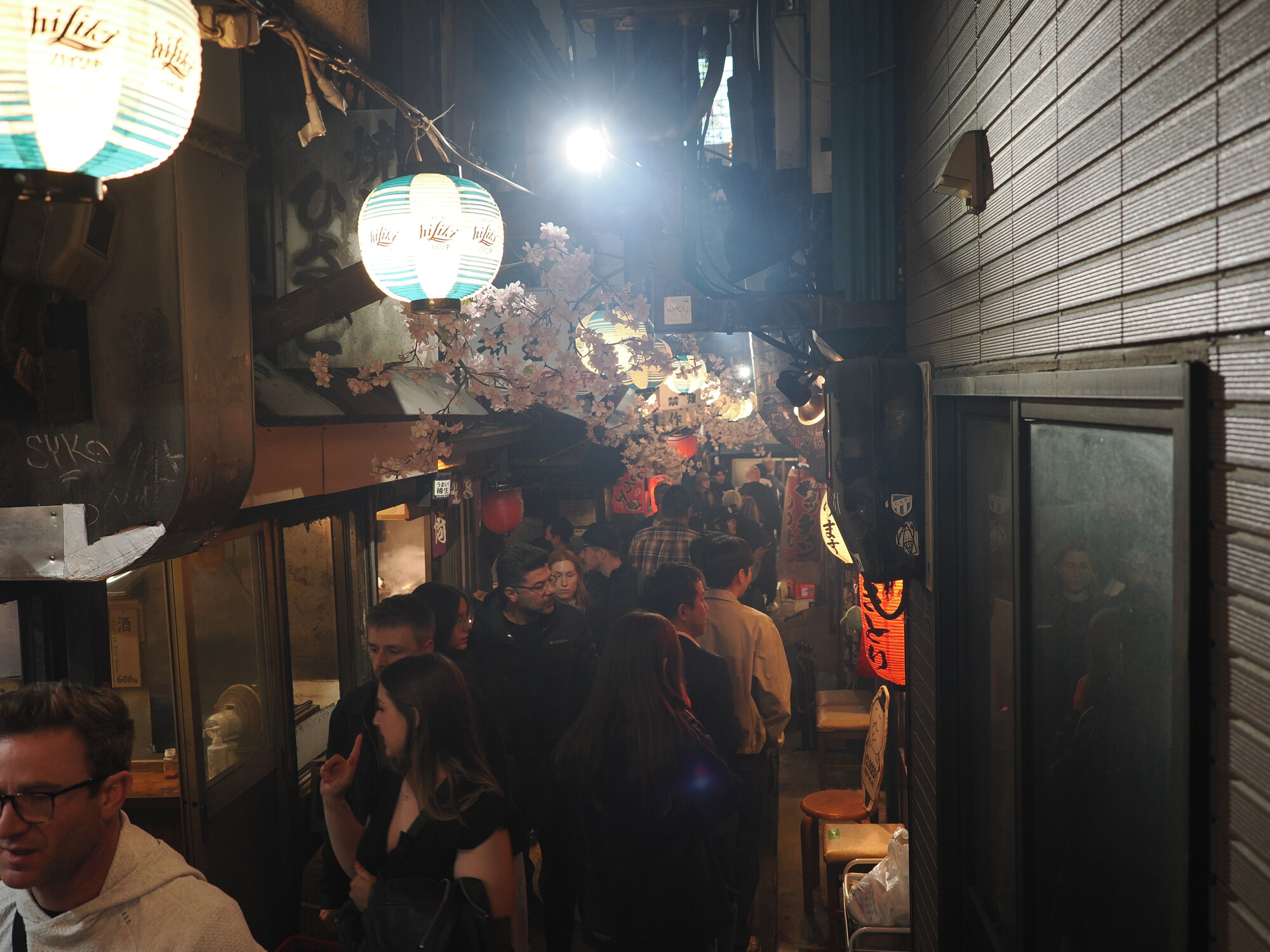 Wąska aleja Omoide Yokocho w Shinjuku — tłum turystów i izakayi po obu stronach