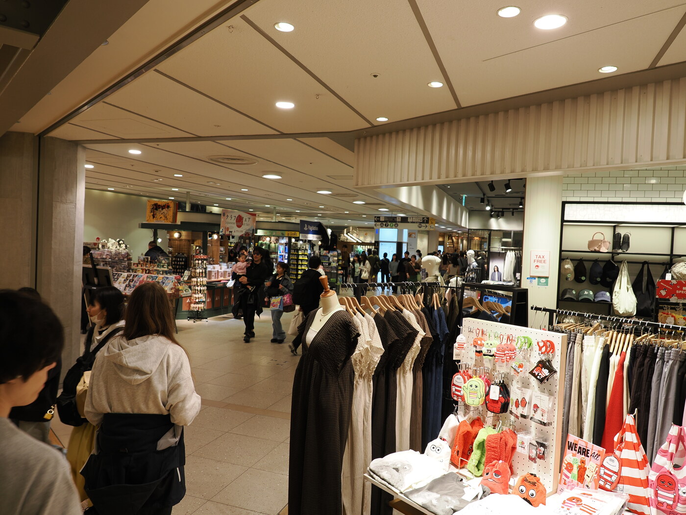 Galeria handlowa Solamachi — wnętrze z butikami mody, TAX FREE, Minions i merchandise po prawej, tłum