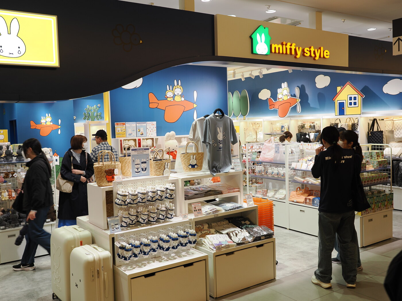 Miffy Style w Solamachi — sklep z merchandise Miffy, niebieska fasada z samolotami, figurki i walizki z Miffy na pierwszym planie