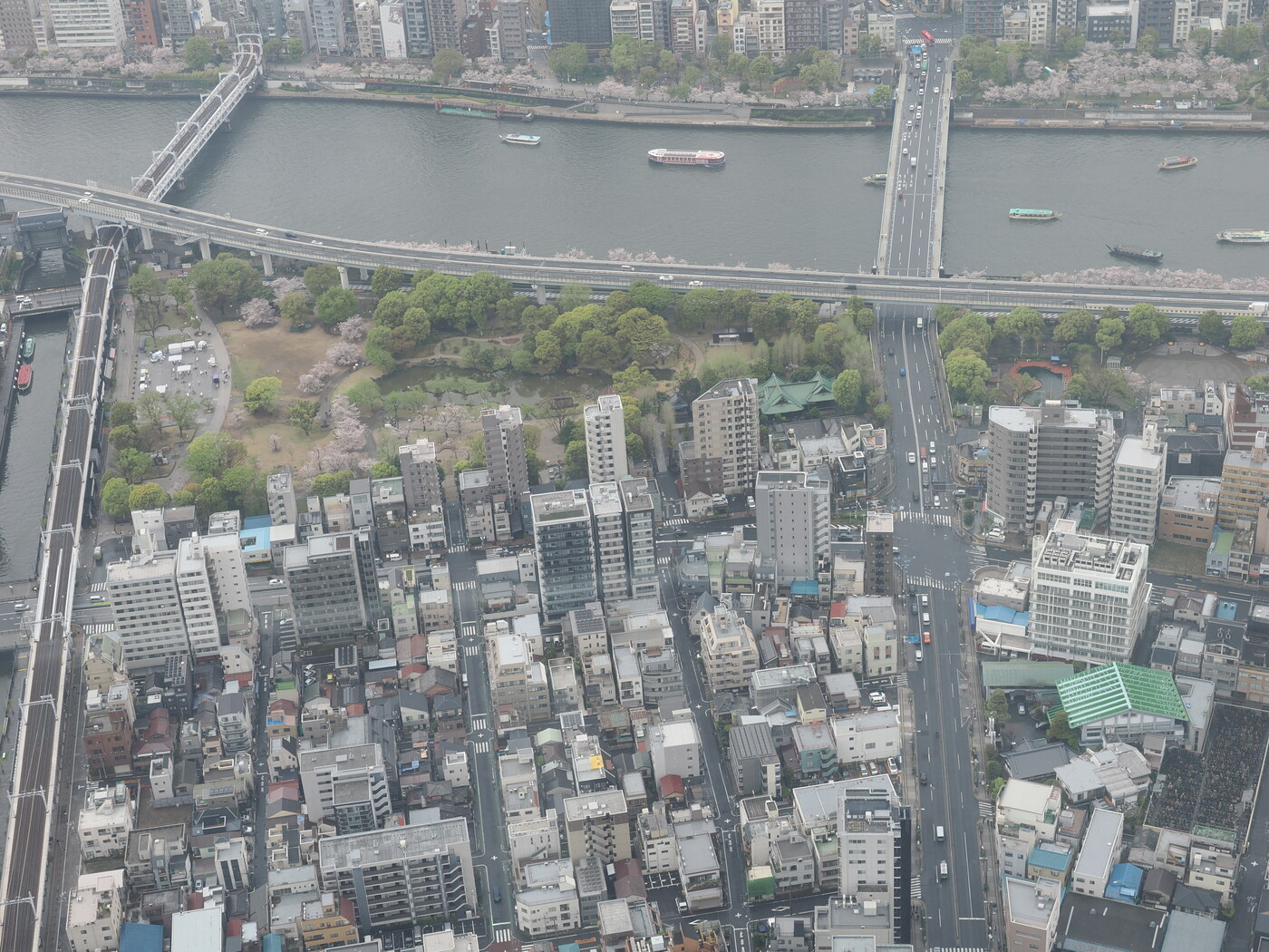 Rzeka Sumida z Tokyo Skytree — mosty, łodzie, park Sumida z kwitnącą sakurą, droga ekspresowa, zabudowa