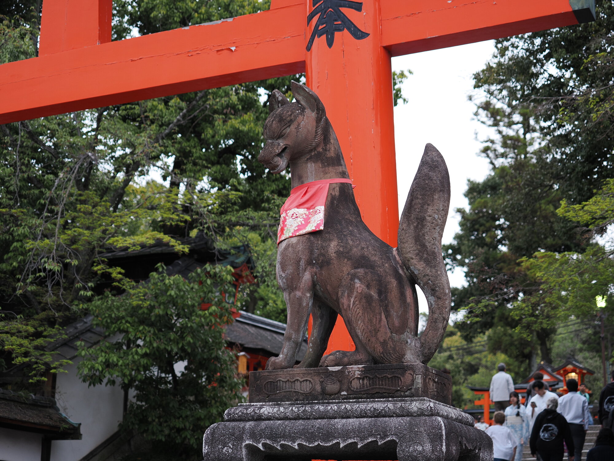 Kamienny posąg lisa kitsune z bliska przy torii Fushimi Inari