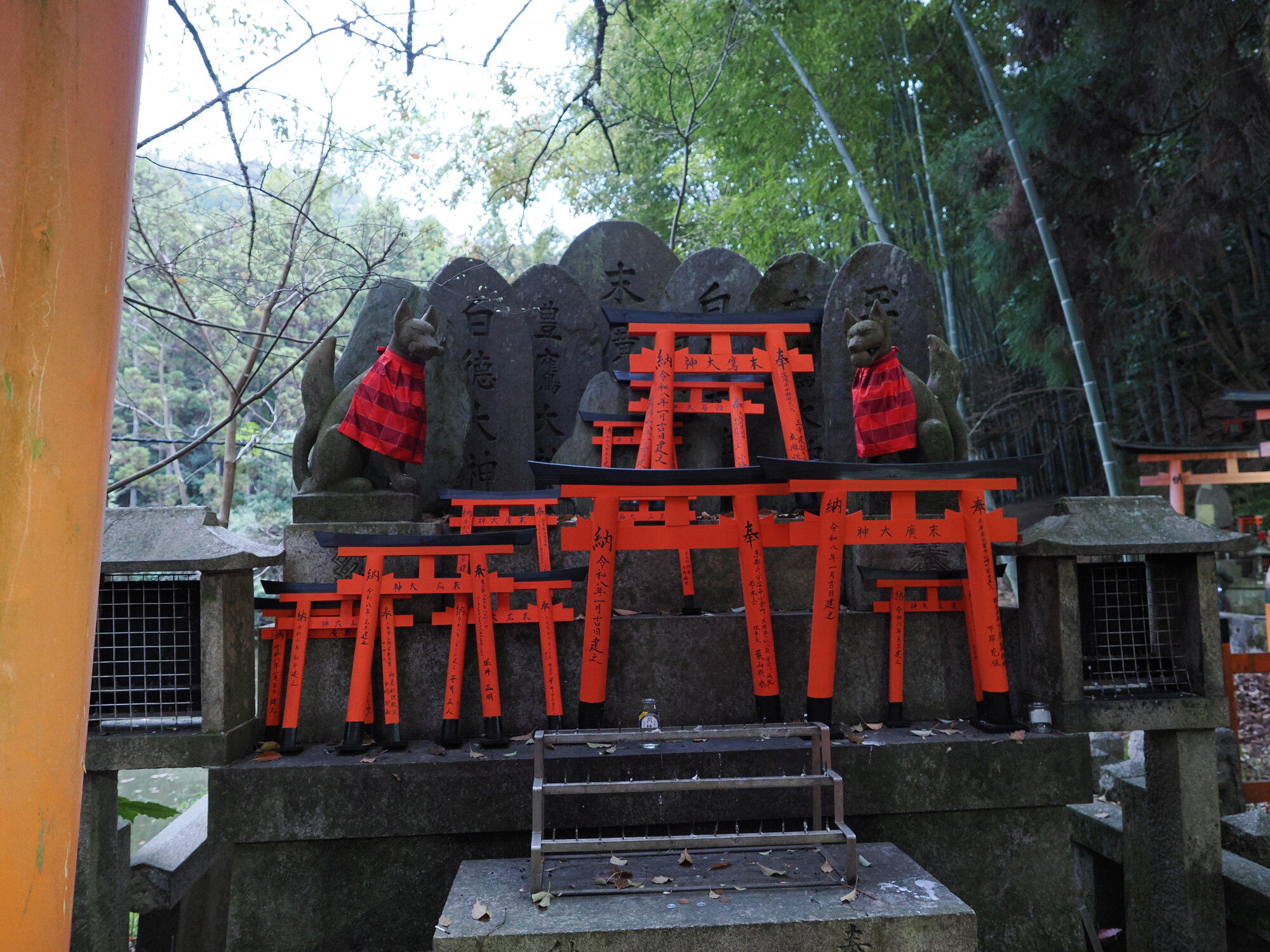 Kapliczka z dwoma kitsune i rzędem miniaturowych torii wotywnych