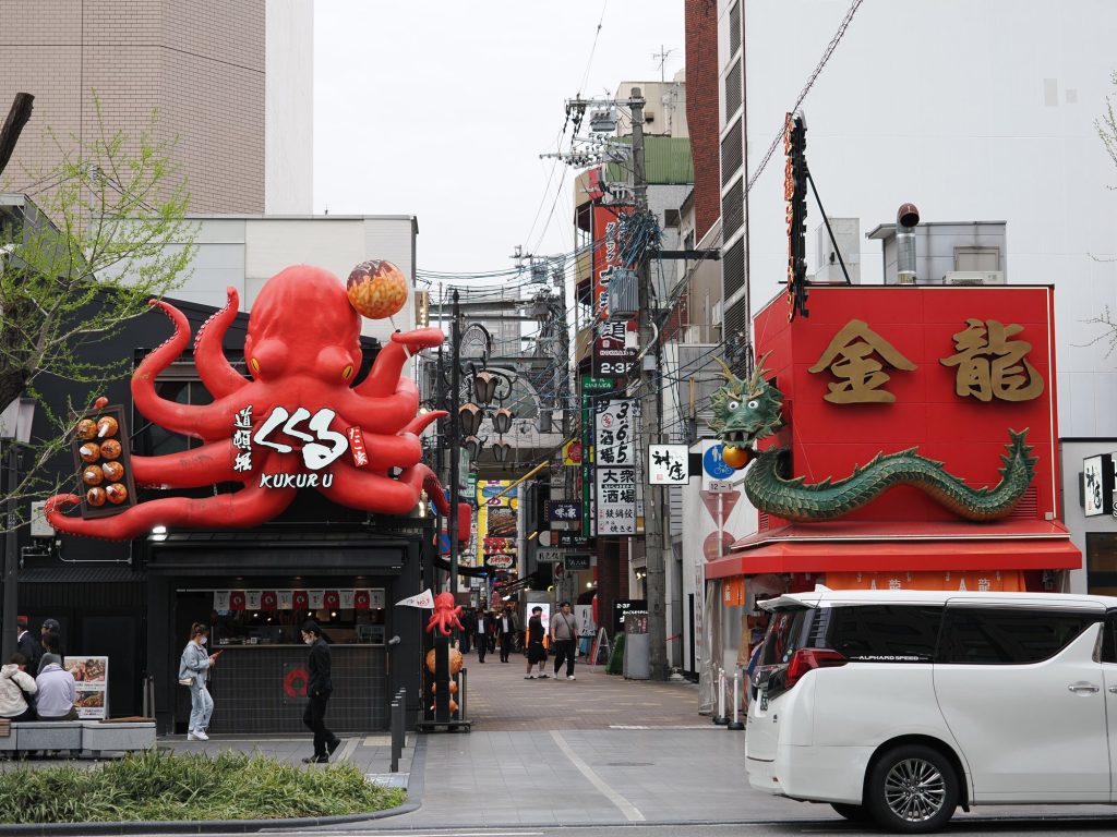 Uliczka Dōtonbori z ogromną ośmiornicą Kukuru i zielonym smokiem Kinryū