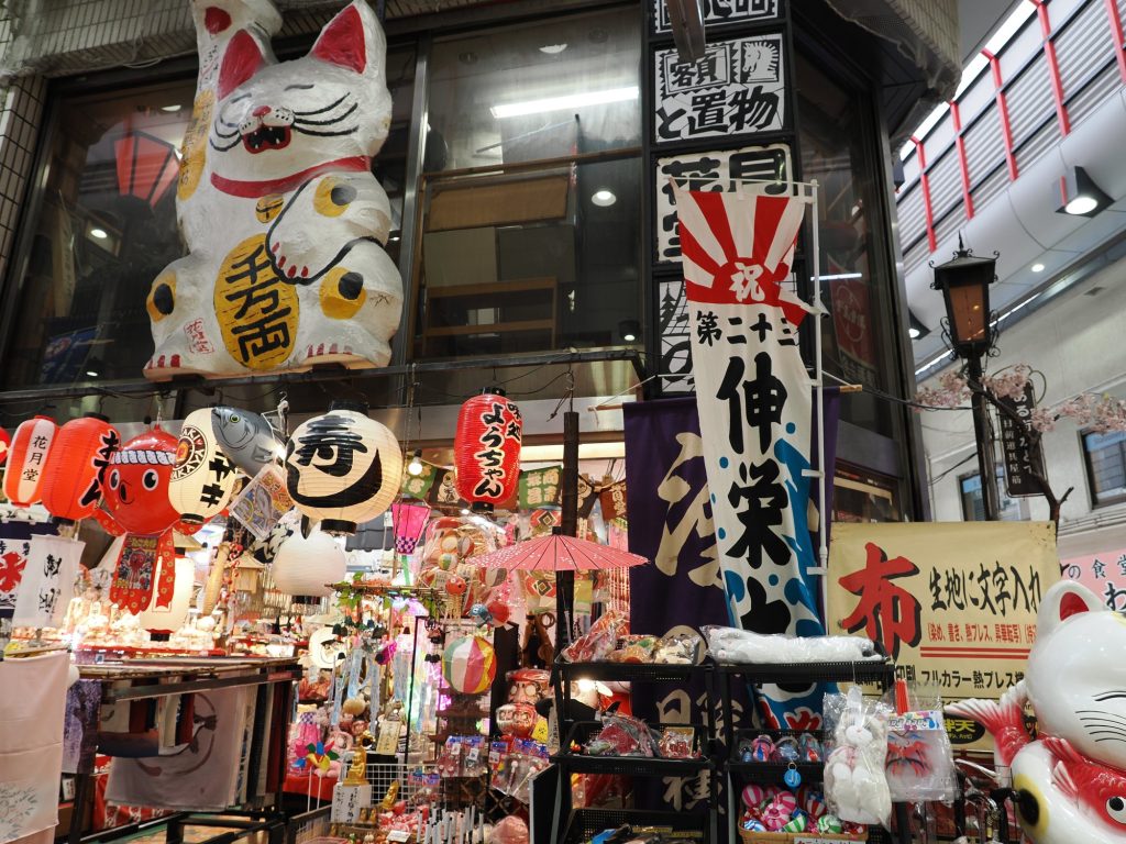 Sklep z rekwizytami teatralnymi w Namba — ogromny maneki neko, lampiony, noren, flagi
