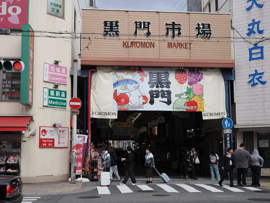 Wejście do Kuromon Market z banerem z rybą, krabem i owocami