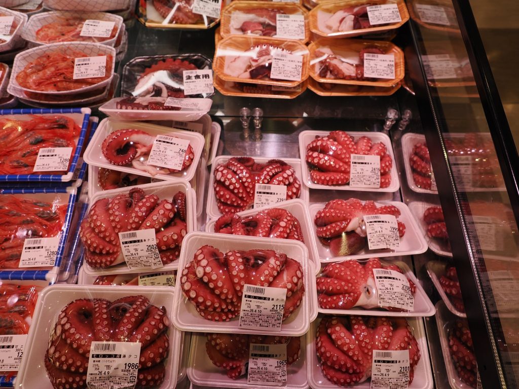 Ośmiornice tako z Maroka na tacach z napisem do spożycia surowego