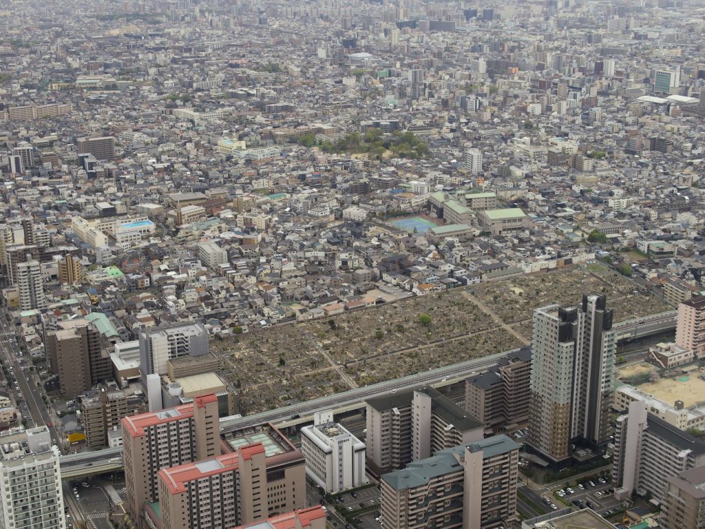 Widok z góry na duży cmentarz otoczony zabudową miejską