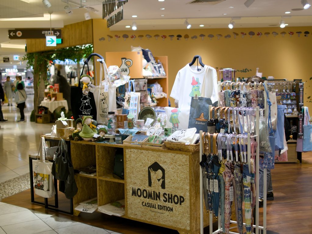 Stoisko Moomin Shop z torkami kubkami i pluszakami