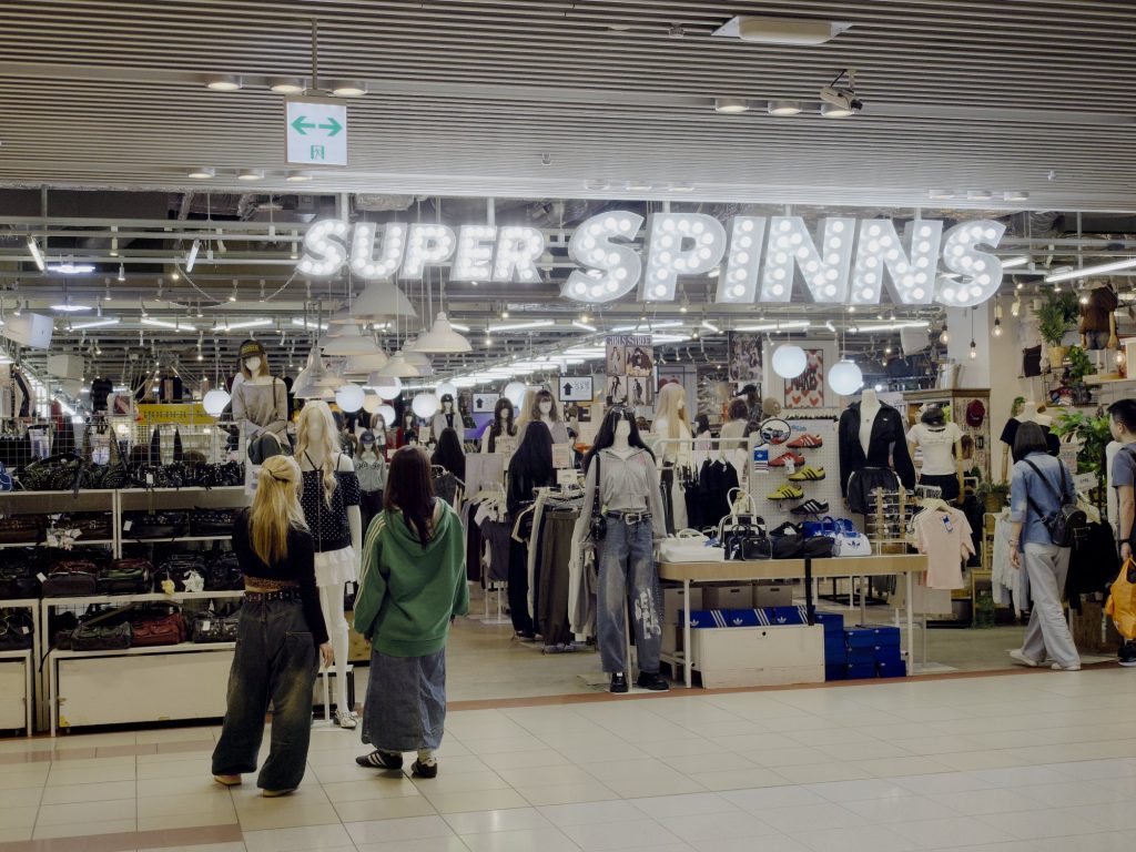 Wejście do sklepu Super SPINNS z neonem marquee