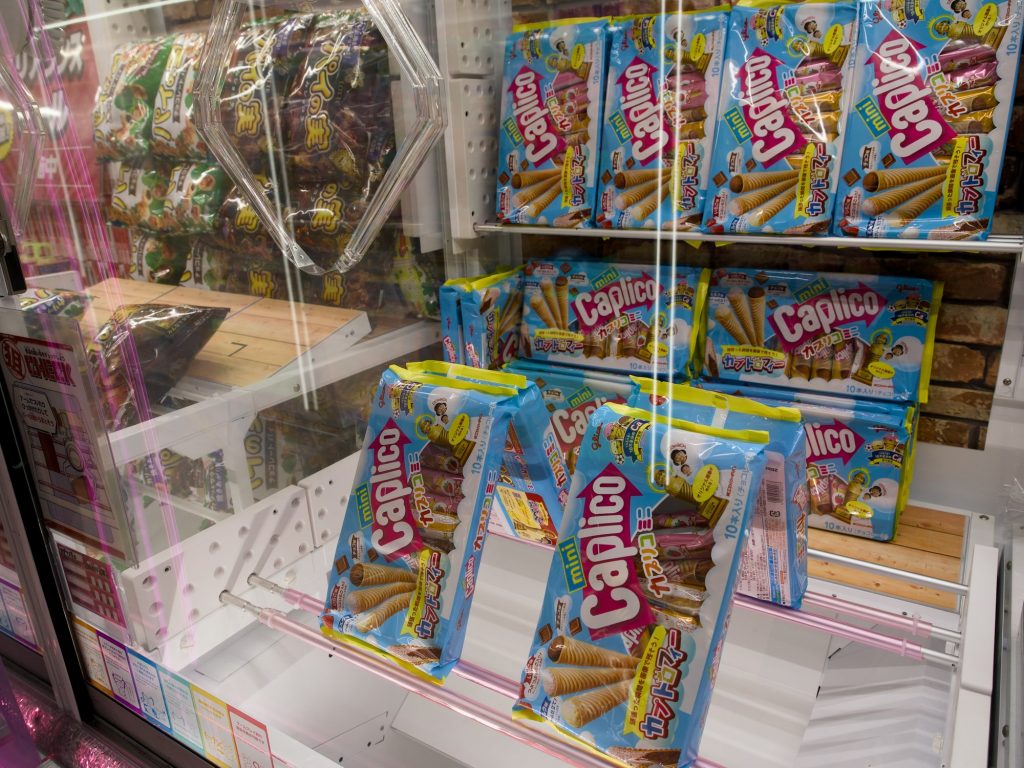 Automat crane game wypełniony paczkami słodyczy Caplico