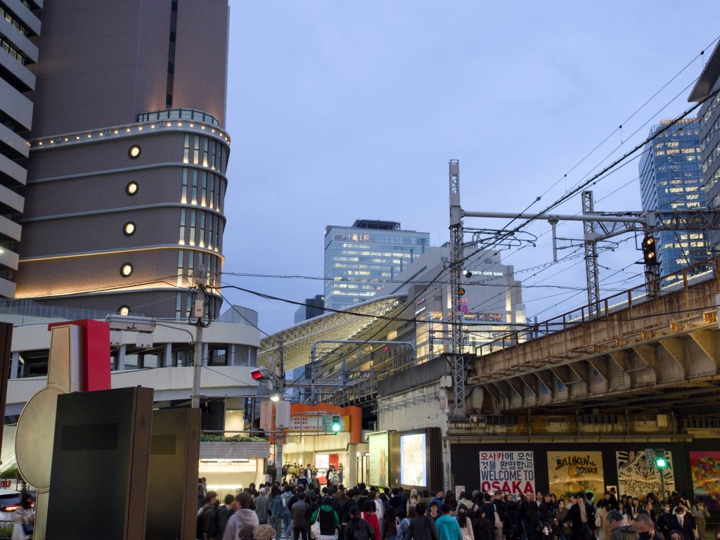 Napis Welcome to Osaka i wiadukt JR przy stacji Osaka nocą