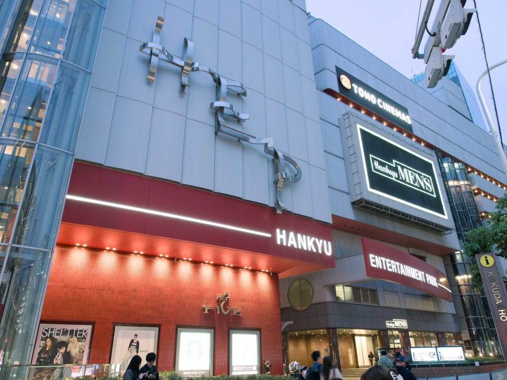 Fasada HEP Five z kinem TOHO i sklepem Hankyu Mens nocą