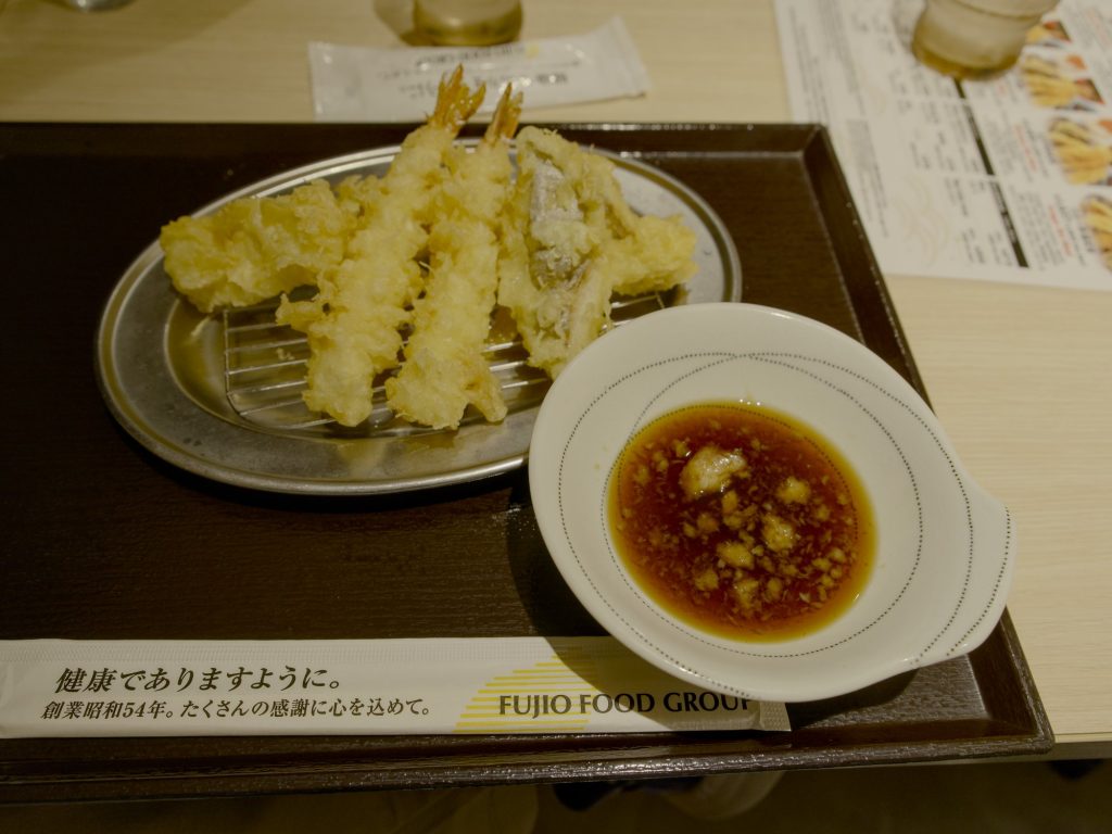 Porcja tempury z krewetkami i warzywami na metalowej kratce