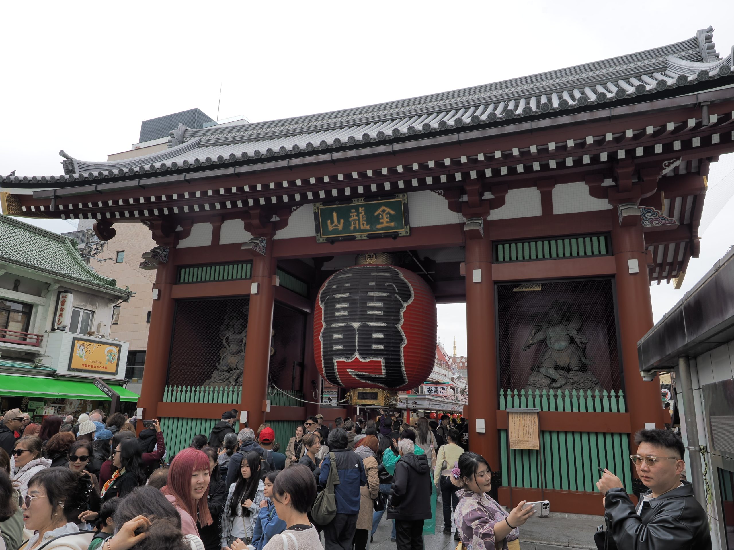 Zbliżenie na bramę Kaminarimon z gigantycznym czerwono-czarnym lampionem i tłumem turystów