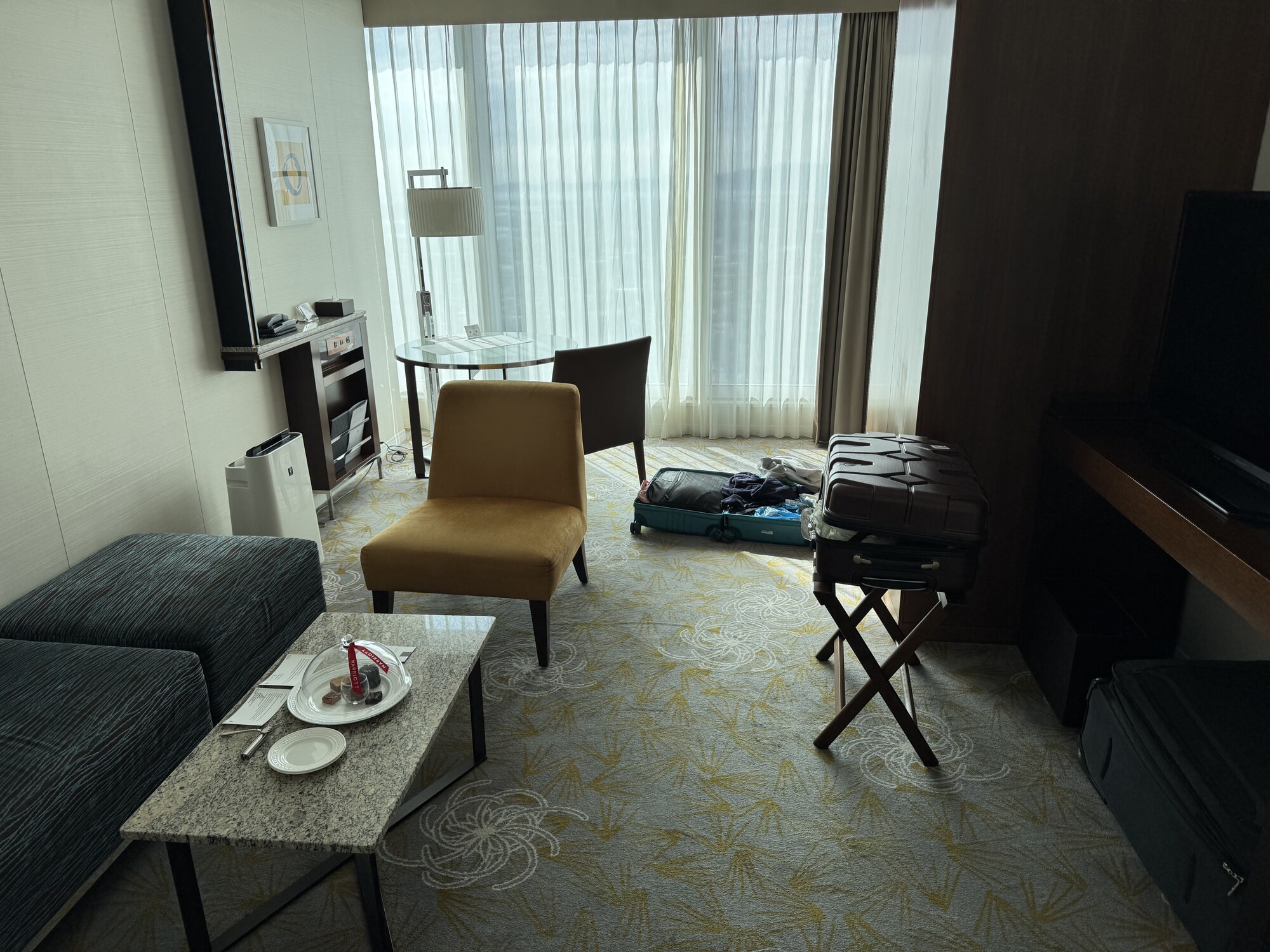 Pokój hotelowy Marriott Osaka — salon z fotelami, walizki, okna na panoramę miasta, luksusowe wnętrze