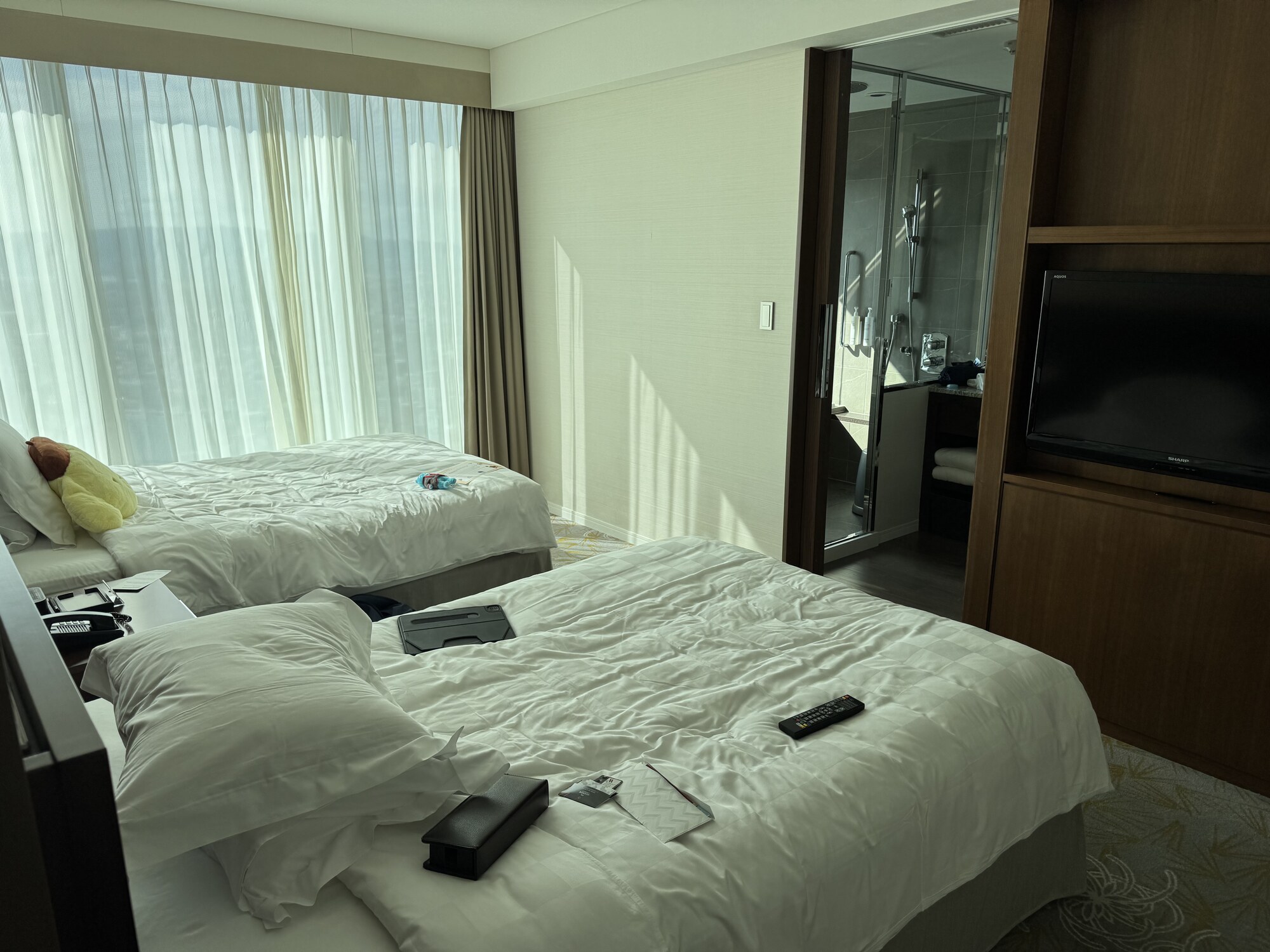 Sypialnia Marriott Osaka — dwa łóżka, telewizor, lampki nocne, szerokie okno z widokiem na miasto