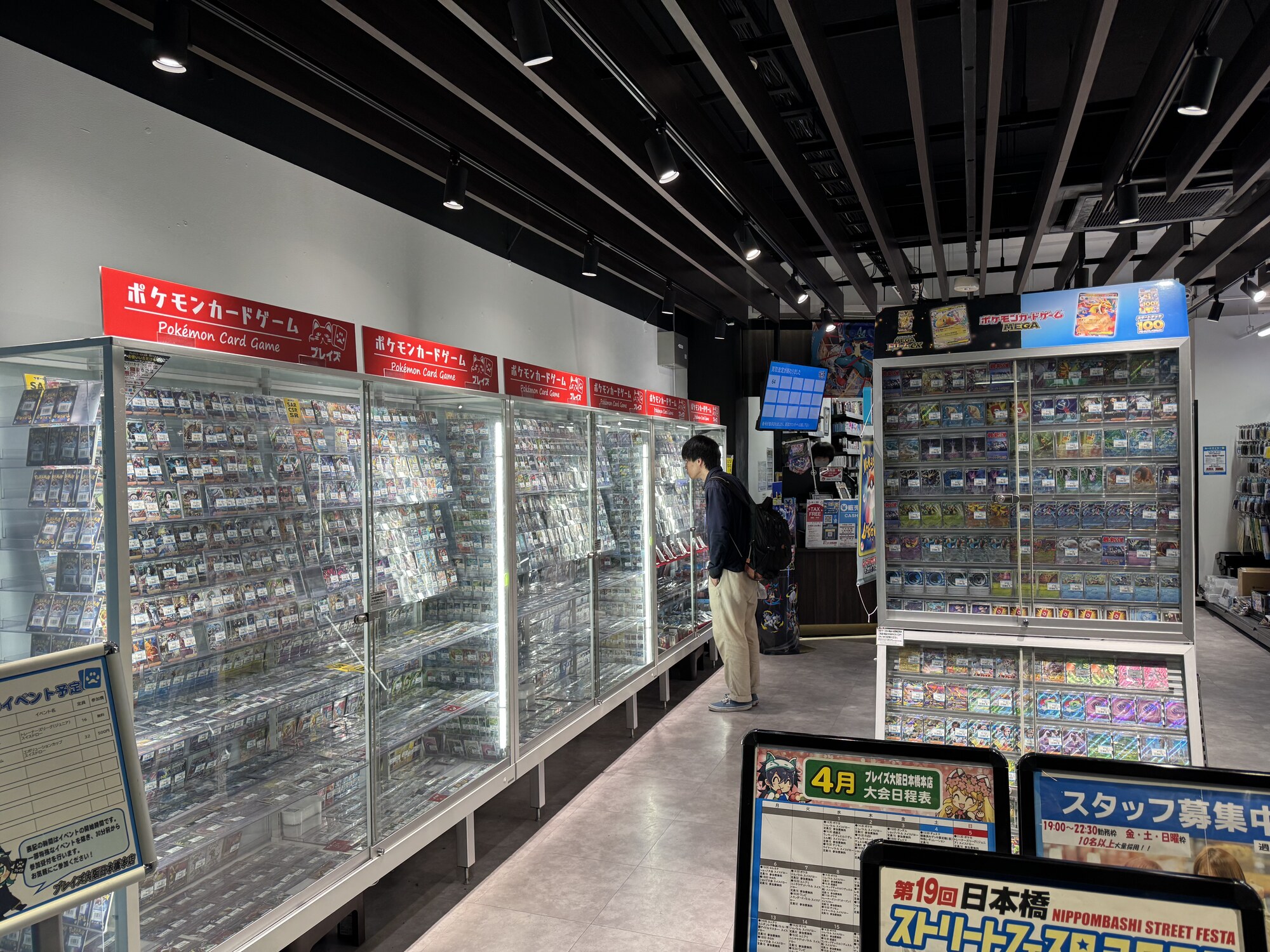 Sklep z kartami Pokemon w Nippombashi — gabloty z kartami, plakaty Pikachu, fani przy stoiskach