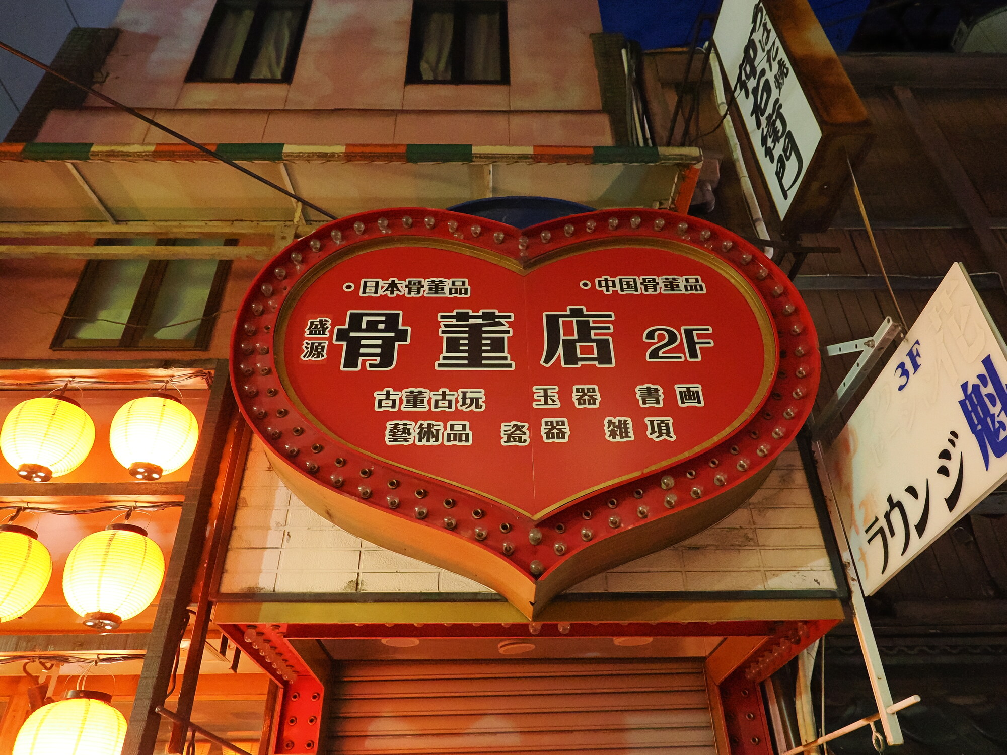 Szyld sklepu antykwarycznego 骨董店 2F w kształcie serca — czerwone serce z żarówkami, napisy Nihon Kottohin i China Kottohin
