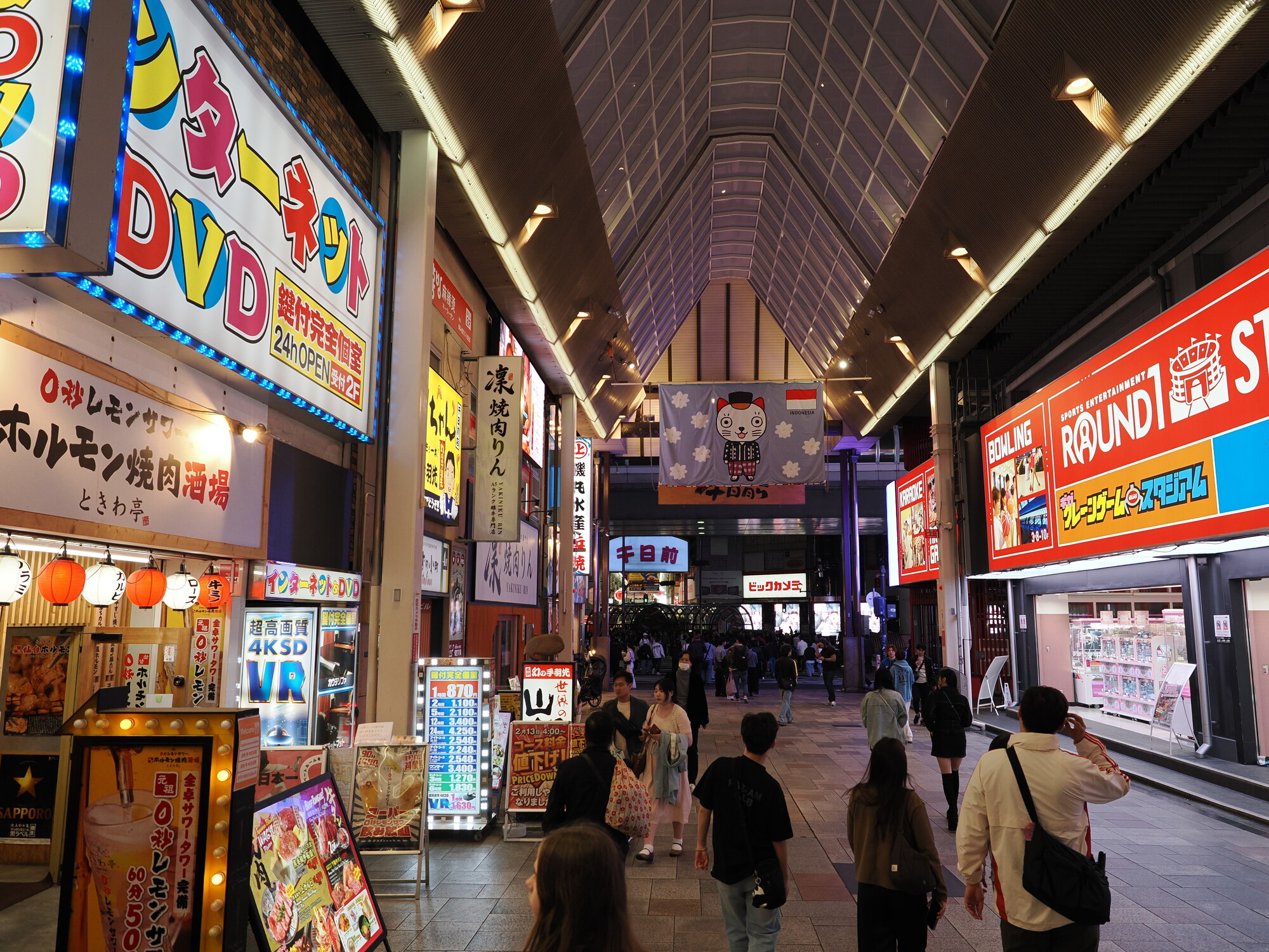 Zadaszony pasaż nocnej Osaki — Round 1 bowling po prawej, yakiniku i hormon-yaki po lewej, szyld Bic Camera w głębi