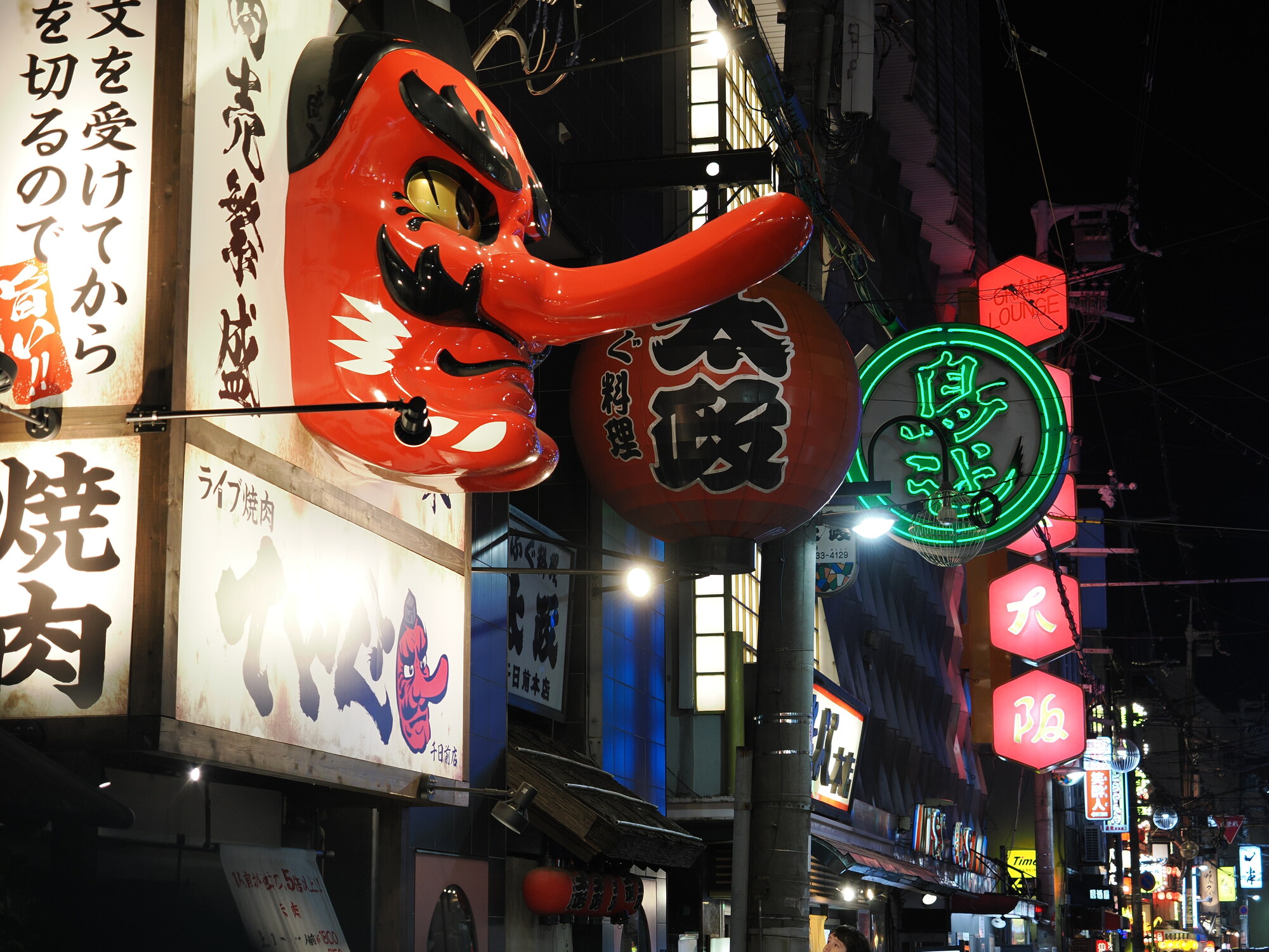 Nocna ulica przy Dotonbori — wielka czerwona maska Hyottoko na restauracji Fugu ryouri po lewej, neony Osaka po prawej