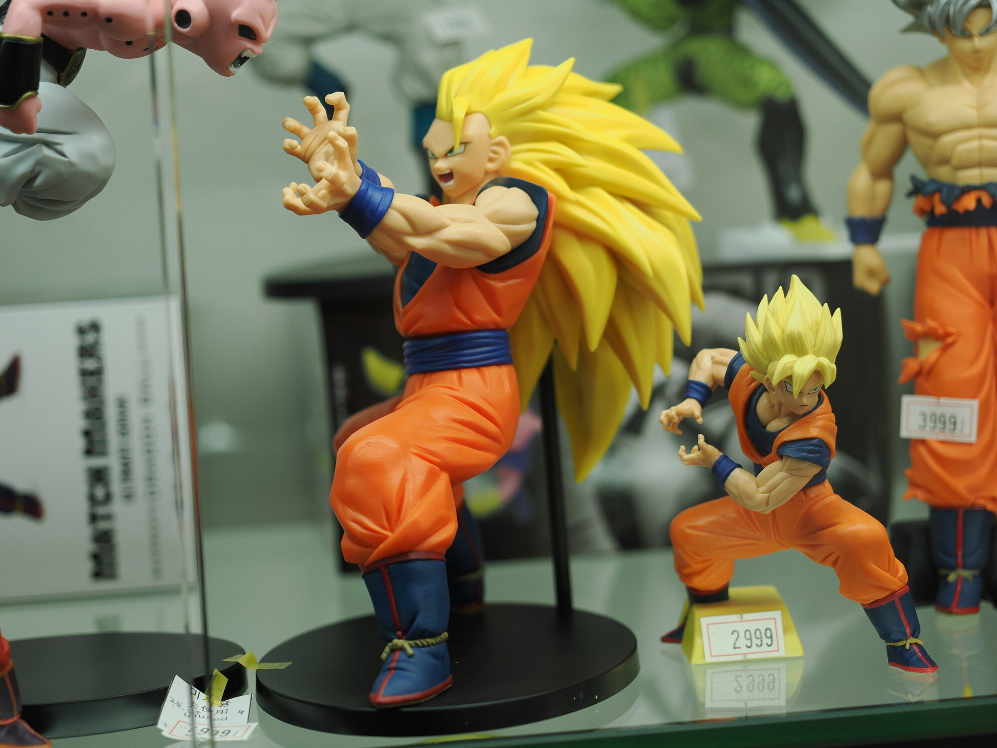 Figurki Son Goku Super Saiyan 3 i Son Goten — Son Goku SSJ3 w pozie ataku z długimi złotymi włosami 2999 jenów, Son Goten SSJ za 2999 jenów, tło Cell i Majin Buu