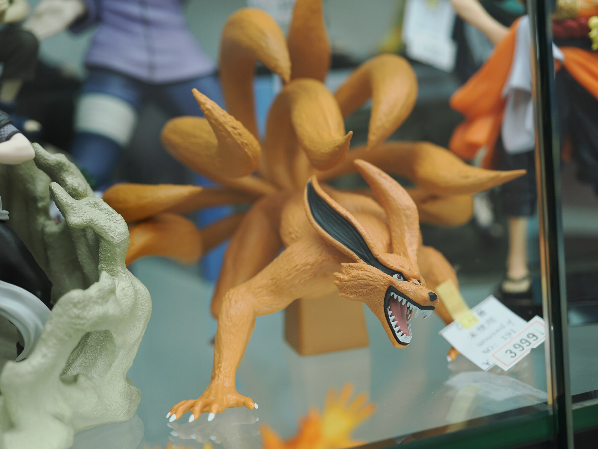 Kyuubi no Kitsune z Naruto — figurka Dziewięcioogoniastego Lisa z Naruto, pomarańczowe ciało i ogony, otwarta paszcza, cena 3999 jenów