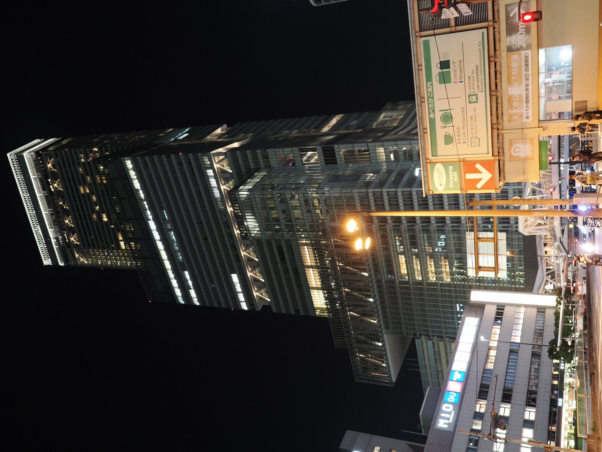 Abeno Harukas nocą — najwyższy budynek w Japonii (300 m) przy stacji Tennoji, skrzyżowanie あべちか z tablicą Shopping Mall, neony MLQ i GU po lewej