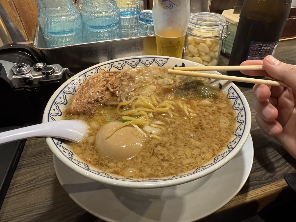 Kamil z obsługą restauracji ばんかつ Bankatu - dwoje pracowników w czarnych uniformach, uśmiechy, drewniane wnętrze z kaligrafią