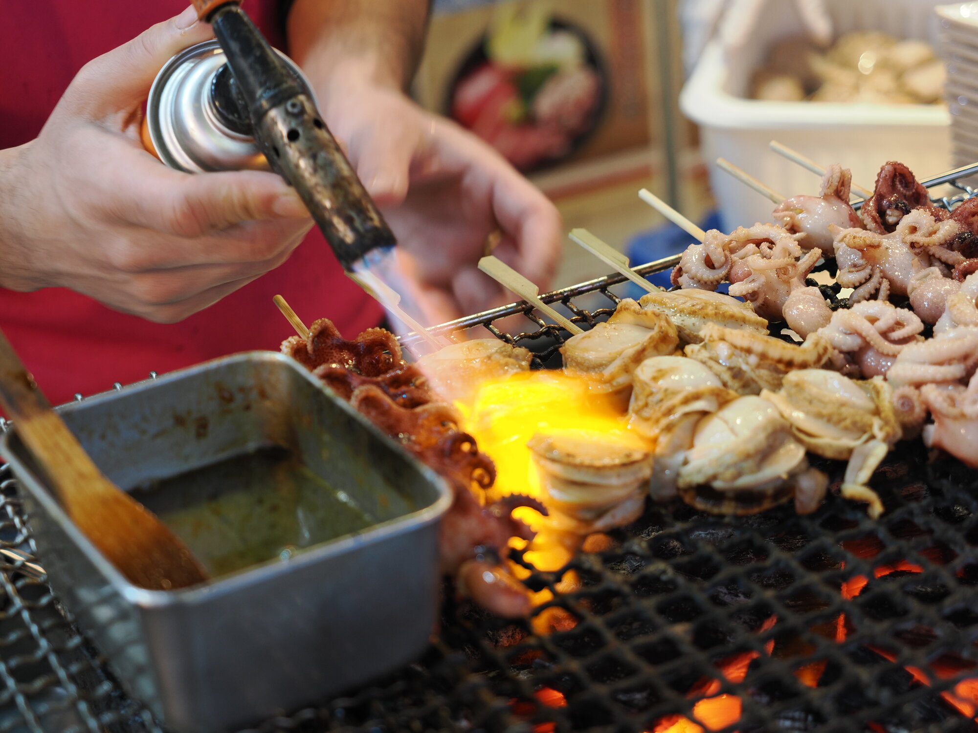 Grill z palnikiem — przegrzebki i ośmiorniczki na węglu drzewnym na Tsukiji